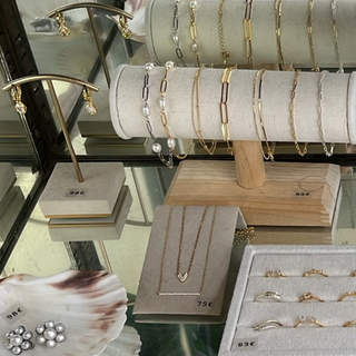 Jewelry display with necklaces, bracelets, and earrings on a glass counter.